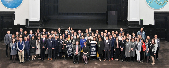 Large crowd of people surround a seated President Ron Liebowitz at a Shanghai event